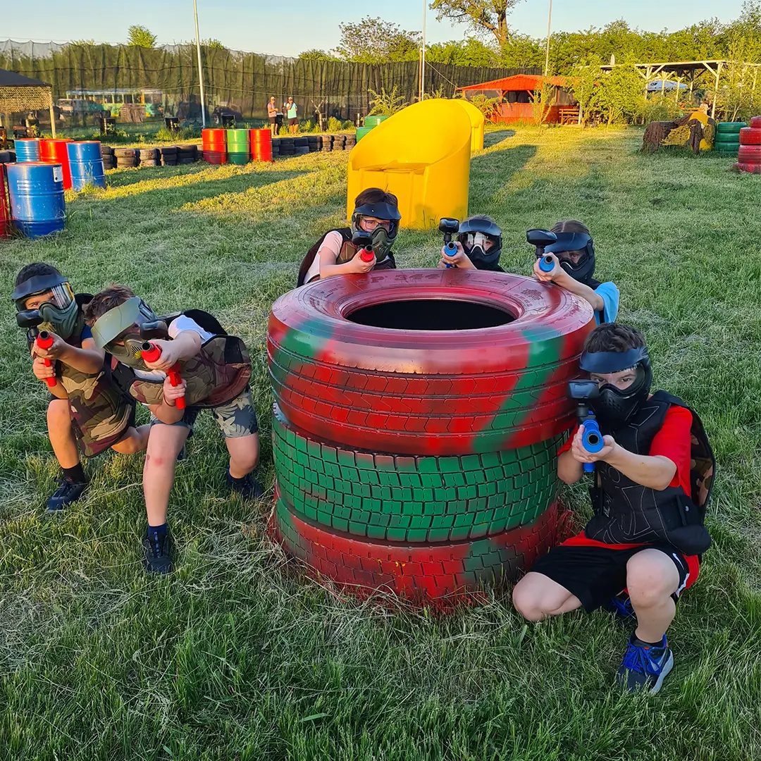 Grup de copii la joacă în spatele unui obstacol, teren KIDS